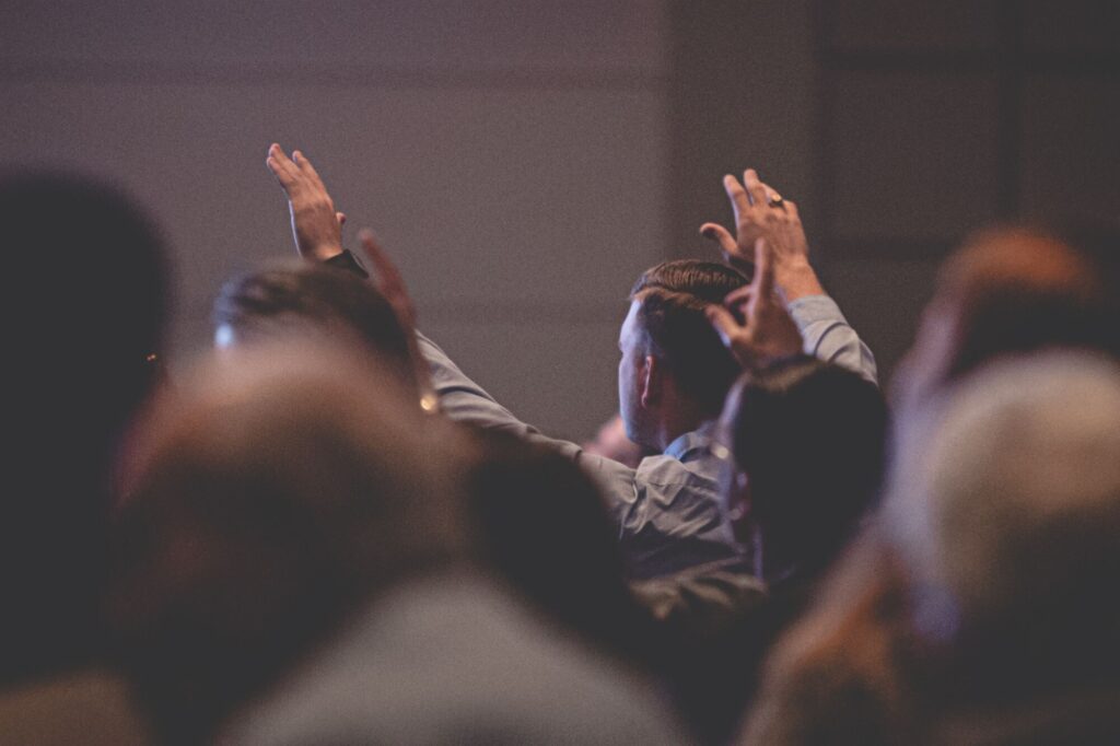 Congregação com as mãos levantadas durante o culto